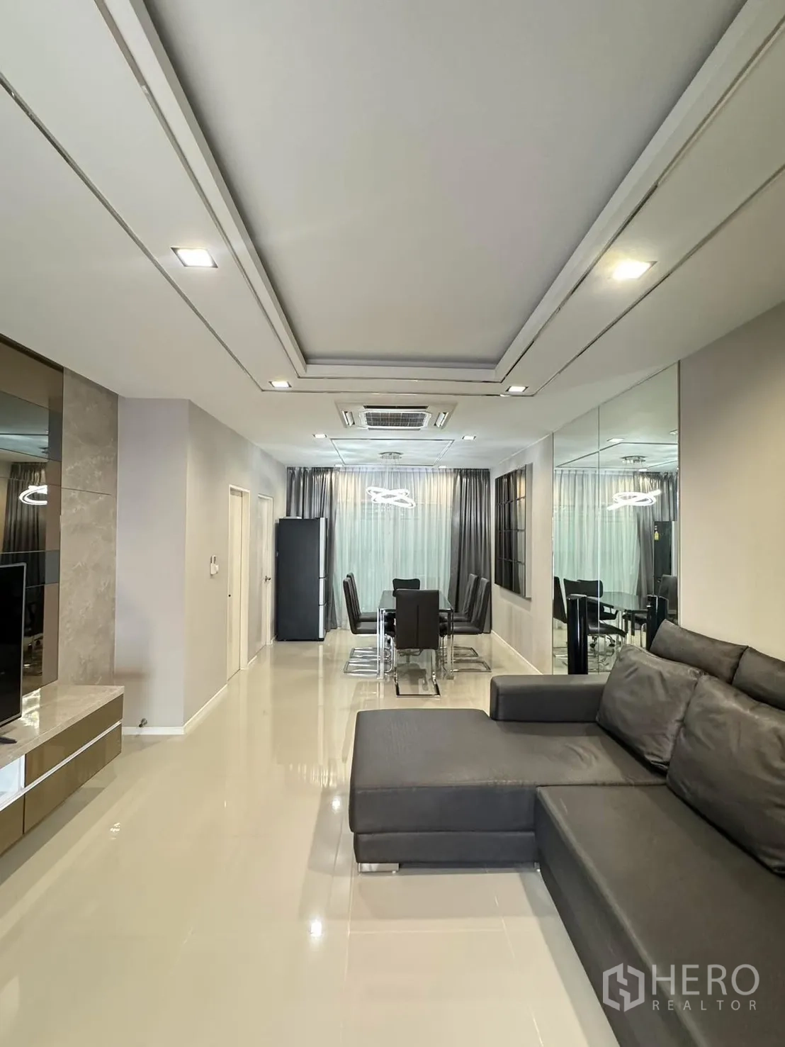 联排别墅 for rent in Suan Luang, Bangkok - 开放式客餐厅，L 型皮沙发与镜面墙。