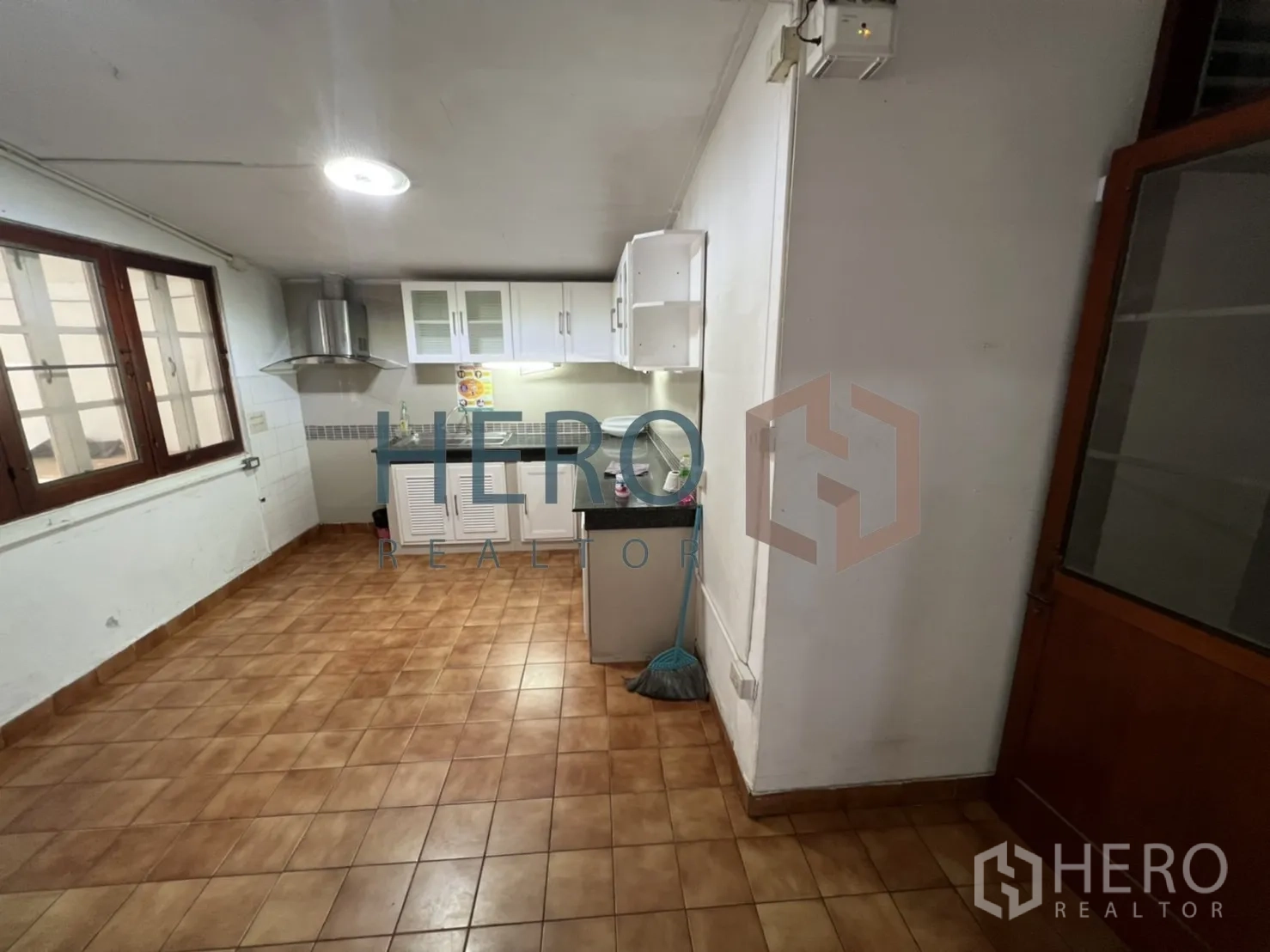 独立式住宅 出租在Watthana, Bangkok - 独立厨房，吊柜、抽油烟机与棕色地砖