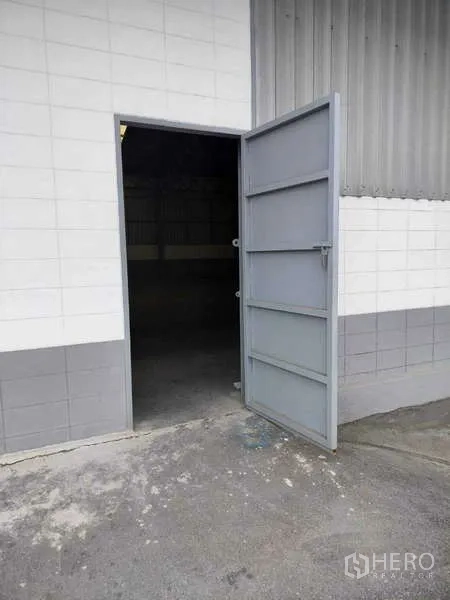 Warehouse for rent in Lat Krabang, Bangkok - Open metal swing door on tiled exterior wall of the warehouse