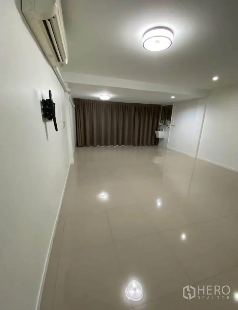 联排别墅 for rent in Phra Khanong, Bangkok - 大面积瓷砖房间，装有空调、顶灯和落地窗帘。