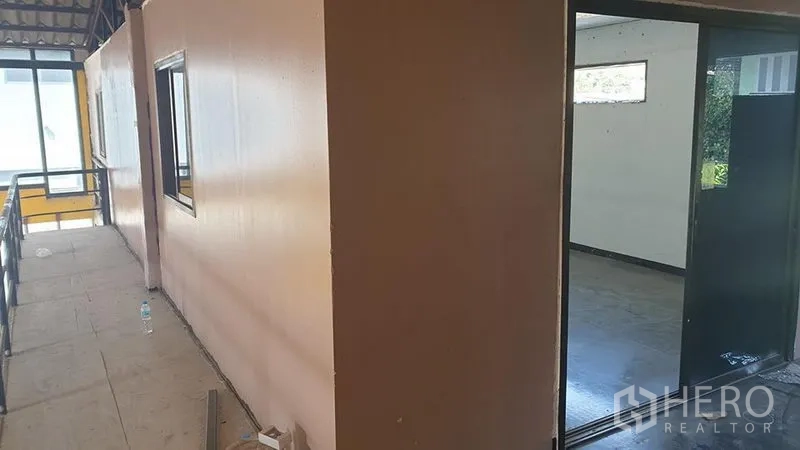 Warehouse for rent in Huai Khwang, Bangkok - Upper mezzanine corridor with partitioned office rooms and a metal railing.