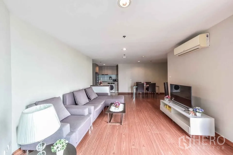 公寓 for rent in Huai Khwang, Bangkok - 开放式客厅，设L型沙发、电视柜与木地板。