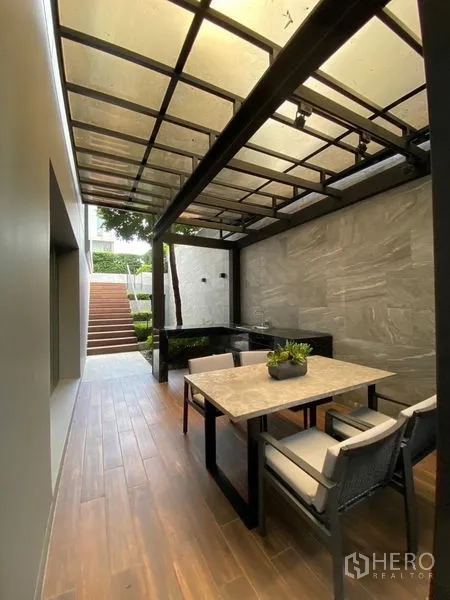 บ้าน ขายในPhaya Thai, Bangkok - มุมรับประทานอาหารกลางแจ้งใต้เพอร์โกลาพร้อมเคาน์เตอร์ครัวและบันไดสู่สวน