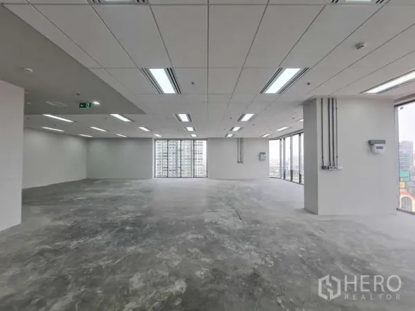 办公空间 出租在Chatuchak, Bangkok - 毛坯办公区，顶置灯具与高窗框出城市景色。