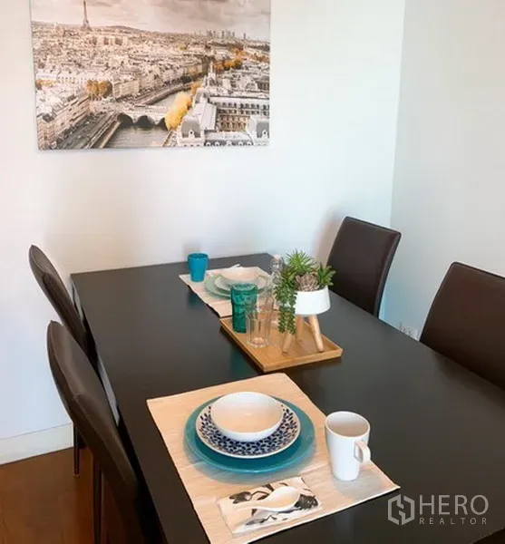 คอนโด ให้เช่าในKhlong Toei, Bangkok - โต๊ะทานข้าวสำหรับ 4 ที่นั่ง จัดจานชามและมีภาพติดผนัง