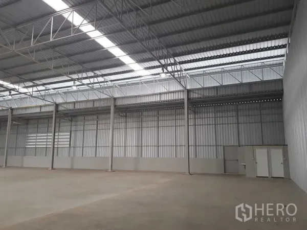 คลังสินค้า ให้เช่าในLat Krabang, Bangkok - ผนังโกดังพร้อมเสาเหล็ก ช่องแสงสกายไลท์ และประตูห้องสาธารณูปโภค