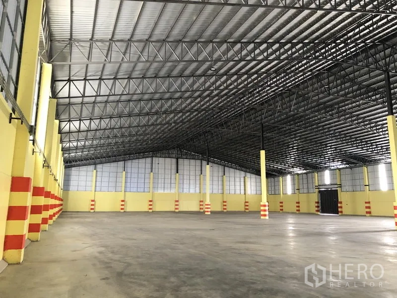 Warehouse for rent in Phra Nakhon Si Ayutthaya - Angled view of a large warehouse hall showing columns, skylights and wide unobstructed floor space.