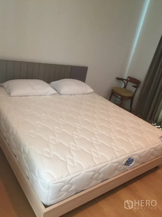 Condominium for rent in Bang Kho Laem, Bangkok - Bright bedroom with queen bed, pillows and floor-to-ceiling curtains in a Bangkok condo.