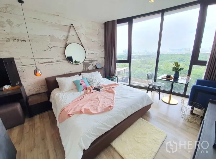 Condominium for rent in Chatuchak, Bangkok - Spacious bedroom with feature wall, pendant lights and full-height windows.