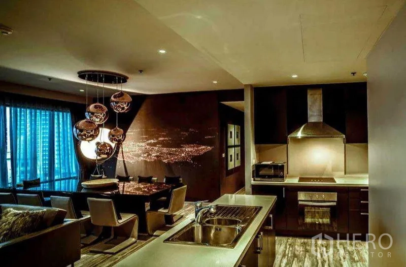 คอนโด ให้เช่าหรือขายในKhlong Toei, Bangkok - ครัวเปิดเชื่อมพื้นที่รับประทานอาหาร ตกแต่งด้วยโคมไฟแขวนดีไซน์และเครื่องดูดควันสแตนเลส