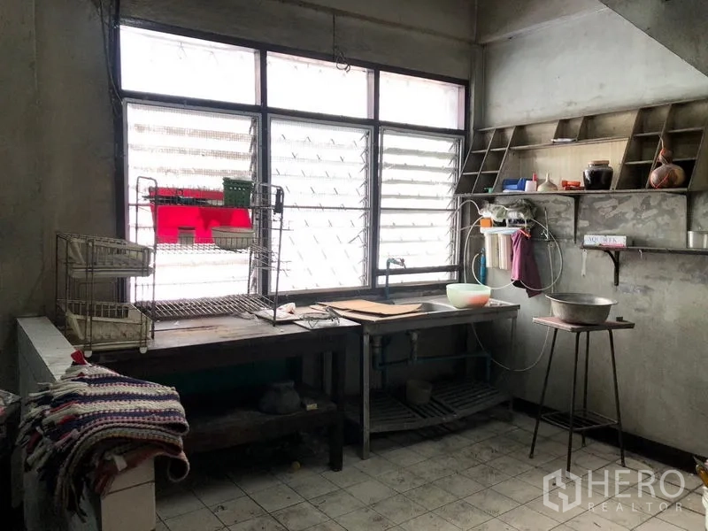 店屋 出租 - 工业风厨房，设百叶大窗、金属操作台、开放层架与瓷砖地面。