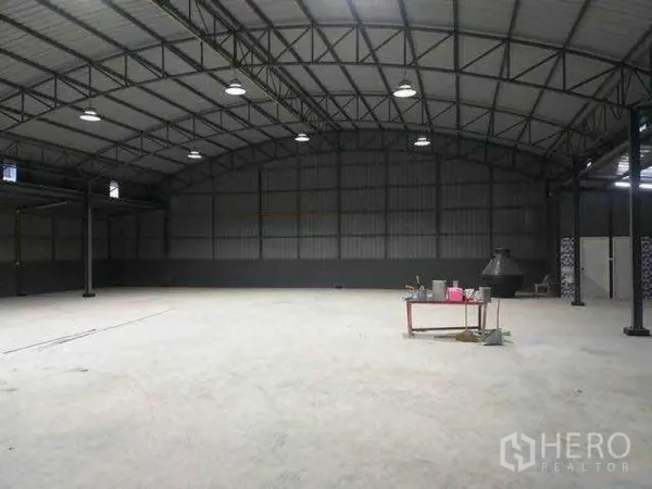 货栈 出租在Khlong Sam Wa, Bangkok - 清水混凝土地坪的宽阔仓库空间，钢板墙与多盏顶灯。