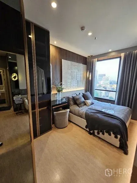 คอนโด ให้เช่า - ห้องนอนหลักพร้อมหน้าต่างวิวเมือง โต๊ะทำงาน และตู้เสื้อผ้าบิวท์อิน