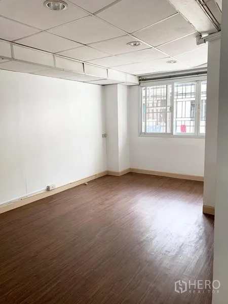 联排别墅 出租在Khlong Toei, Bangkok - 卧室带木质地板与带防护栏的窗户。