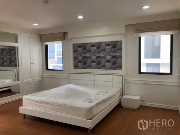 Condominium for rent in Watthana, Bangkok - Second bedroom with built-in wardrobes, wall mirror, two windows and recessed lighting.