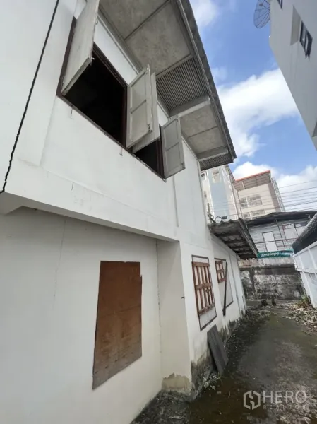 บ้าน ให้เช่าในSathon, Bangkok - มุมใกล้หน้าต่างชั้นบนและชายคาบ้านสีขาวหลังเก่า มีตึกเมืองด้านหลัง