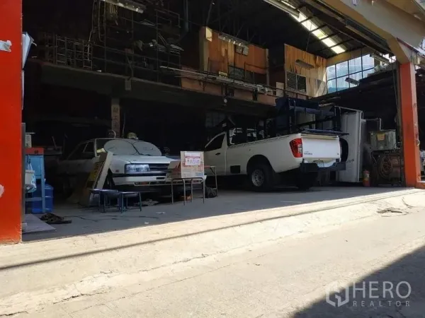 คลังสินค้า ให้เช่าในYan Nawa, Bangkok - ช่องหน้าของโกดัง มีรถกระบะสีขาวและพื้นที่ทำงานใต้หลังคาเปิดโล่ง