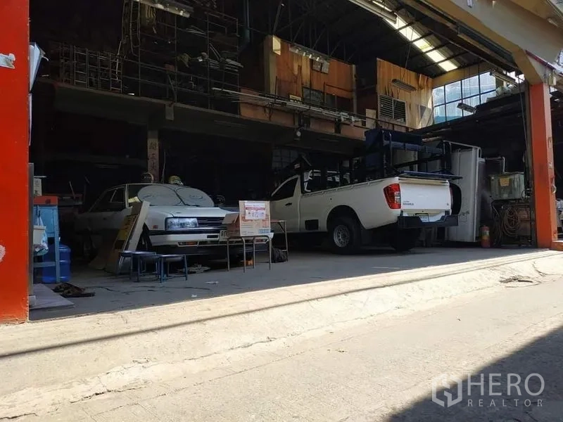 คลังสินค้า ให้เช่าในYan Nawa, Bangkok - ช่องหน้าของโกดัง มีรถกระบะสีขาวและพื้นที่ทำงานใต้หลังคาเปิดโล่ง