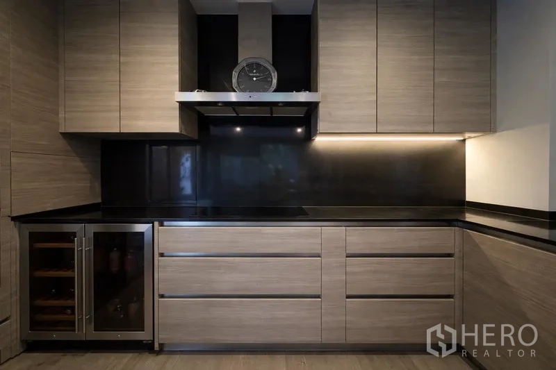 Semi-detached House for rent in Watthana, Bangkok - Sleek kitchen with black stone countertop and under-cabinet lighting.