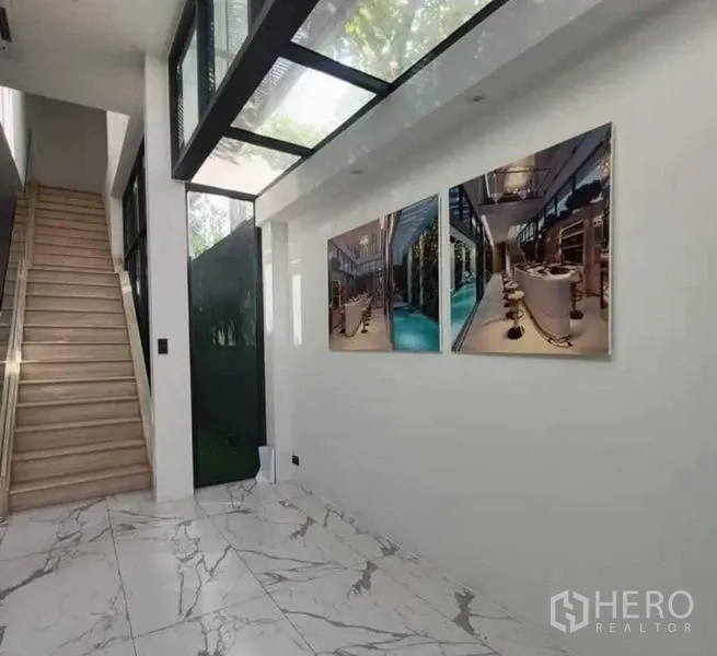 Home Office for rent in Suan Luang, Bangkok - Lobby with marble-look floor, glass skylight and staircase with wall art.
