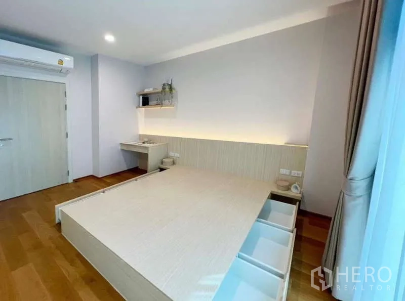 ทาวน์เฮาส์ ให้เช่าหรือขายในSaphan Sung, Bangkok - ห้องนอนมินิมอล เตียงยกพื้นมีลิ้นชัก โต๊ะทำงานเล็ก และไฟซ่อน