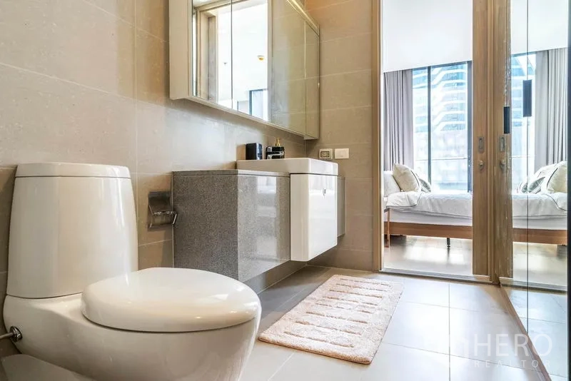 คอนโด ให้เช่าในPathum Wan, Bangkok - มุมมองจากห้องน้ำสู่ห้องนอน พร้อมเคาน์เตอร์ลอย ตู้กระจก และโถสุขภัณฑ์