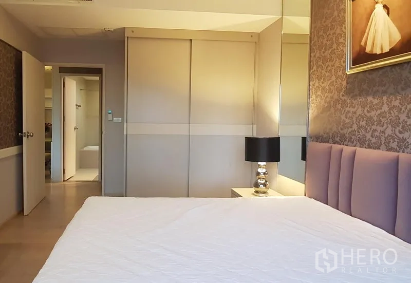 公寓 出租在Khlong Toei, Bangkok - 舒适卧室，软包床头与推拉衣柜，通往套内卫浴。