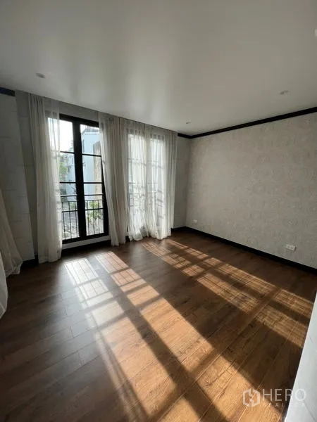 สำนักงานที่บ้าน ให้เช่าหรือขายในWatthana, Bangkok - ห้องนอนรับแสง พื้นไม้ และประตูกระจกเปิดสู่ระเบียง