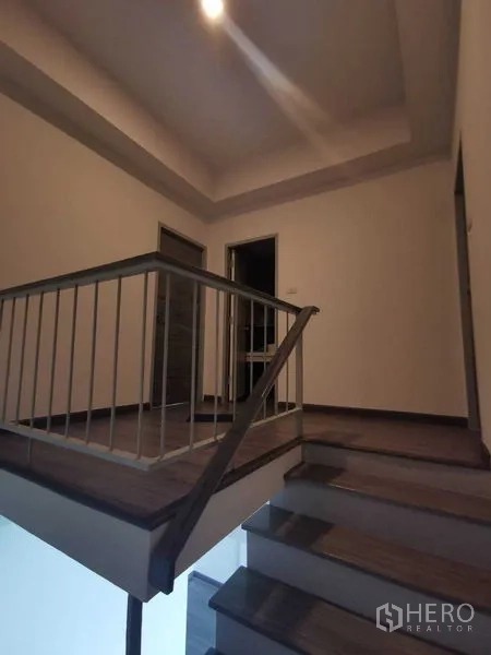 Home Office for rent or sale - Staircase landing with metal handrail and recessed lighting.