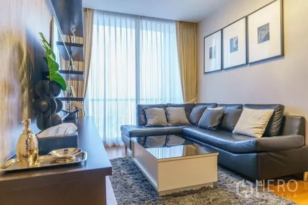 คอนโด ให้เช่าหรือขายในBang Rak, Bangkok - ห้องนั่งเล่นสว่าง โซฟาหนังตัวแอล พรมฟูก และผ้าม่านสูงจรดเพดานรับวิวเมือง