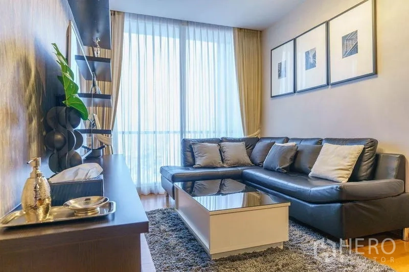 คอนโด ให้เช่าหรือขายในBang Rak, Bangkok - ห้องนั่งเล่นสว่าง โซฟาหนังตัวแอล พรมฟูก และผ้าม่านสูงจรดเพดานรับวิวเมือง