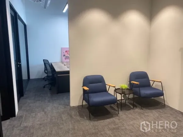办公空间 出租在Pathum Wan, Bangkok - 接待等候区，两把蓝色休闲椅与边几，临走廊。