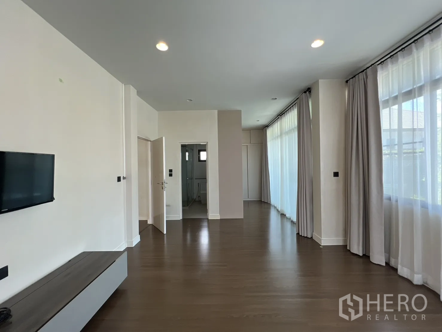 独立式住宅 出售在Bang Kapi, Bangkok - 主卧墙面电视与通往套卫的门。