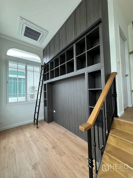 Detached House for rent - Landing area with tall dark cabinetry, ladder and large window