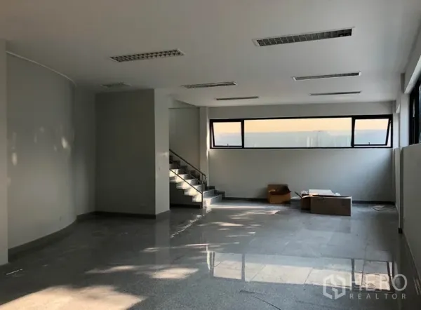 办公空间 出租在Khlong Toei, Bangkok - 开放式办公室内景，石材地面、室内楼梯与长条窗户。