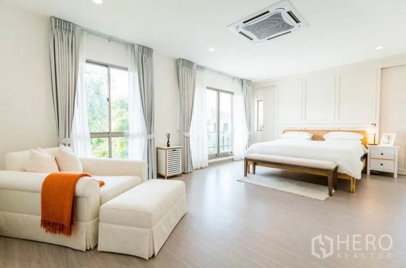 独立式住宅 出租 - 明亮的主卧，配大床与沙发，落地窗与阳台门，天花板嵌入式空调。