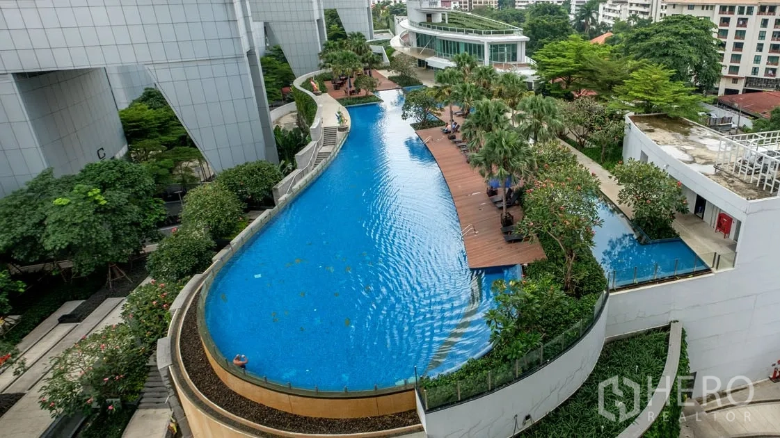 คอนโด ให้เช่าในKhlong Toei, Bangkok - สระว่ายน้ำสไตล์ลากูนพร้อมทางเดินไม้ เตียงอาบแดด และสวนเขียวชอุ่มของคอนโด