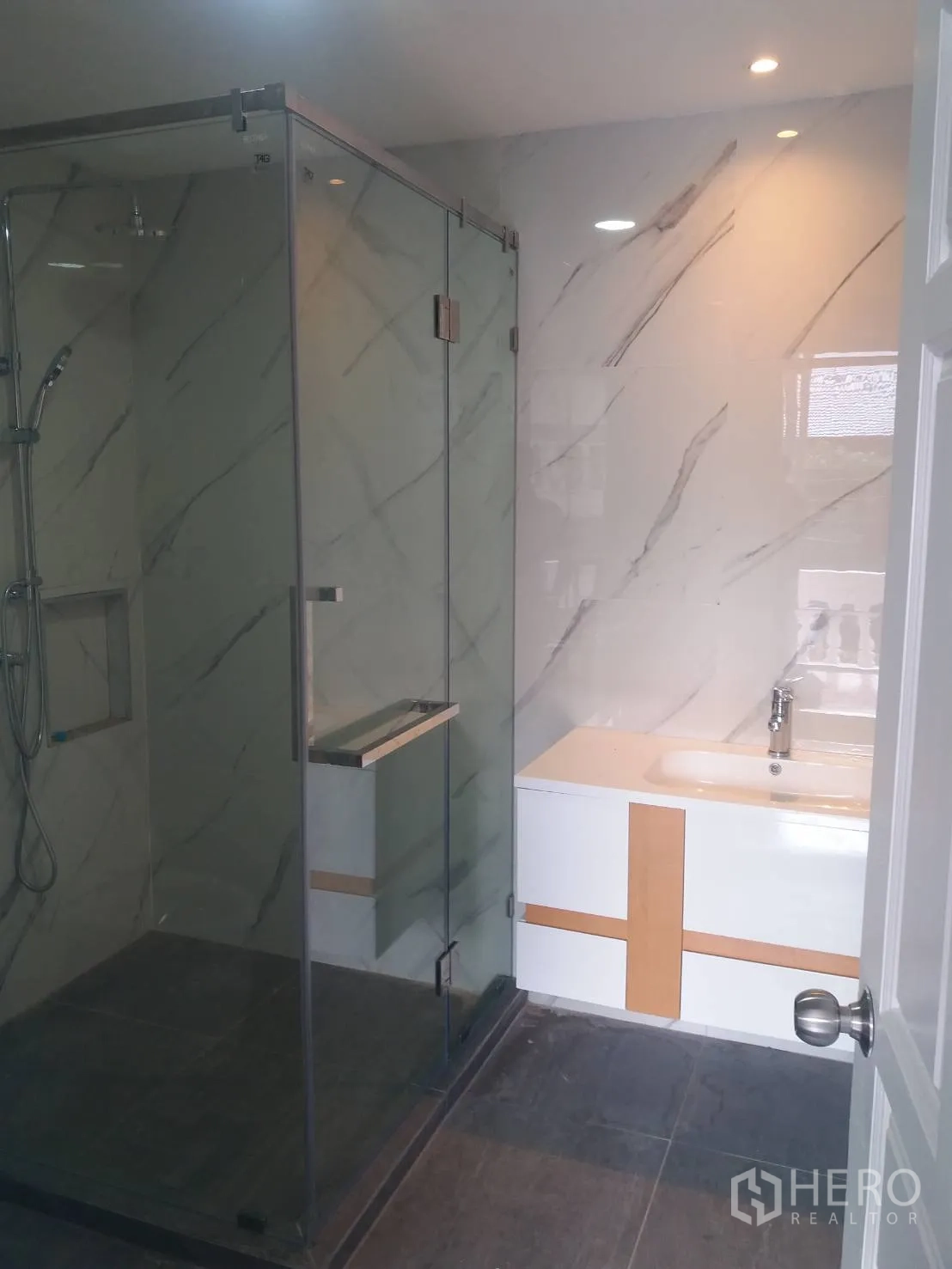 ทาวน์เฮาส์ ให้เช่าในKhlong Toei, Bangkok - ห้องน้ำโมเดิร์น กั้นกระจกอาบน้ำ ผนังลายหินอ่อน และเคาน์เตอร์อ่างล้างหน้า.