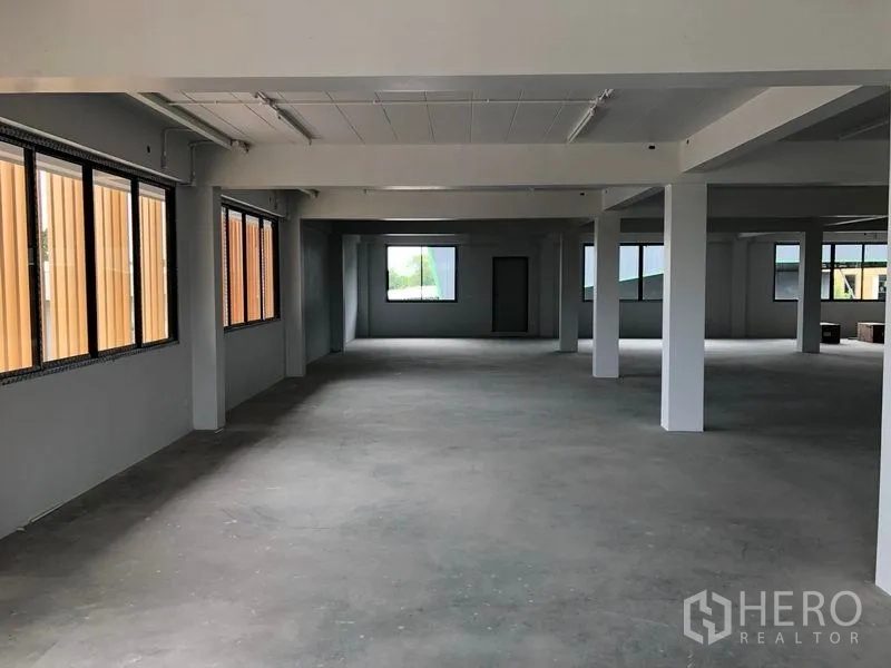 Office Space for rent in Lat Krabang, Bangkok - Open-plan office floor with concrete flooring, white columns and large windows.