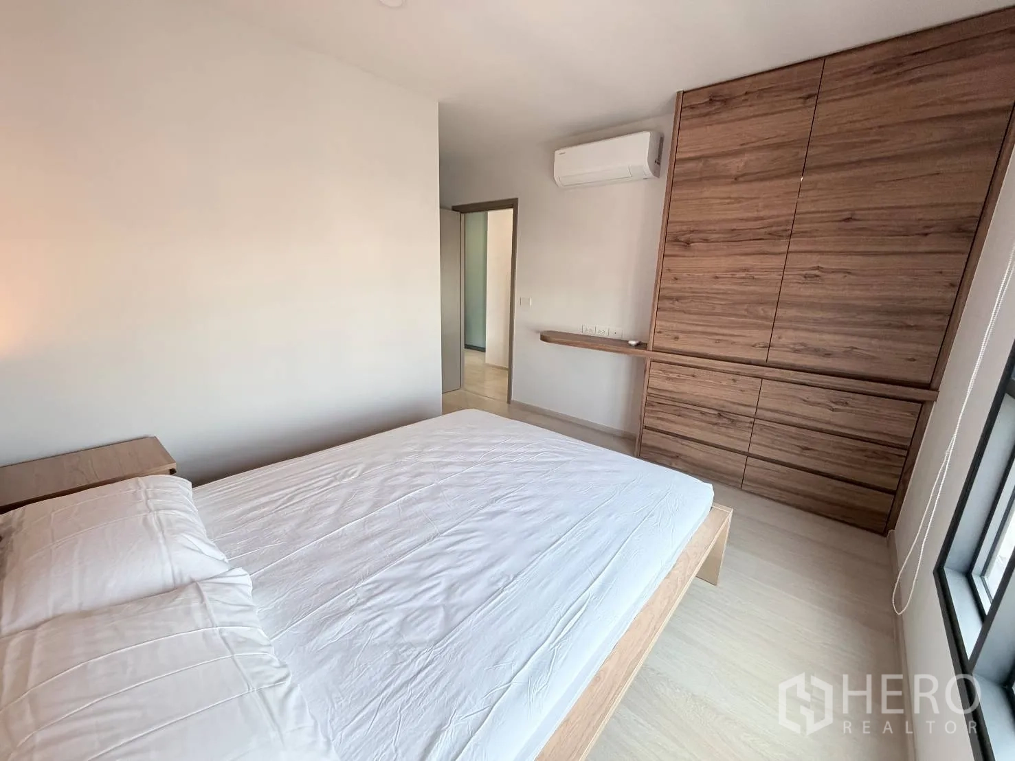 คอนโด for rent in Din Daeng, Bangkok - มุมห้องนอนเห็นตู้เสื้อผ้าบิลท์อินไม้ เครื่องปรับอากาศ และหน้าต่างบานใหญ่