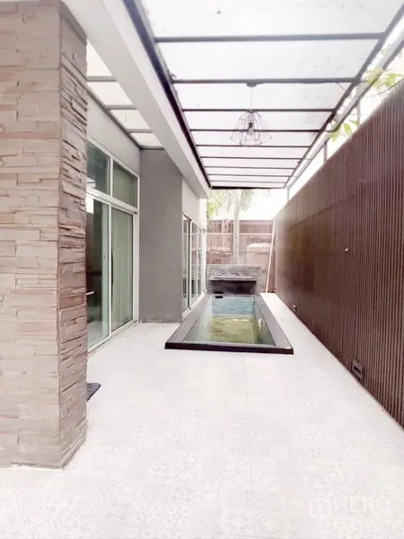 Townhouse for rent or sale in Don Mueang, Bangkok - Covered side patio with a narrow private plunge pool and stone feature wall.