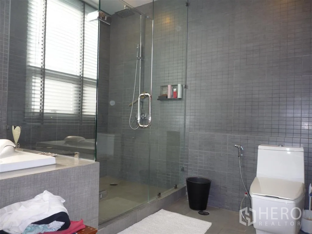 บ้าน ให้เช่าในKhan Na Yao, Bangkok - ห้องน้ำสไตล์โมเดิร์นพร้อมฝักบัวกระจกบานใหญ่ อ่างล้างหน้า และโถสุขภัณฑ์