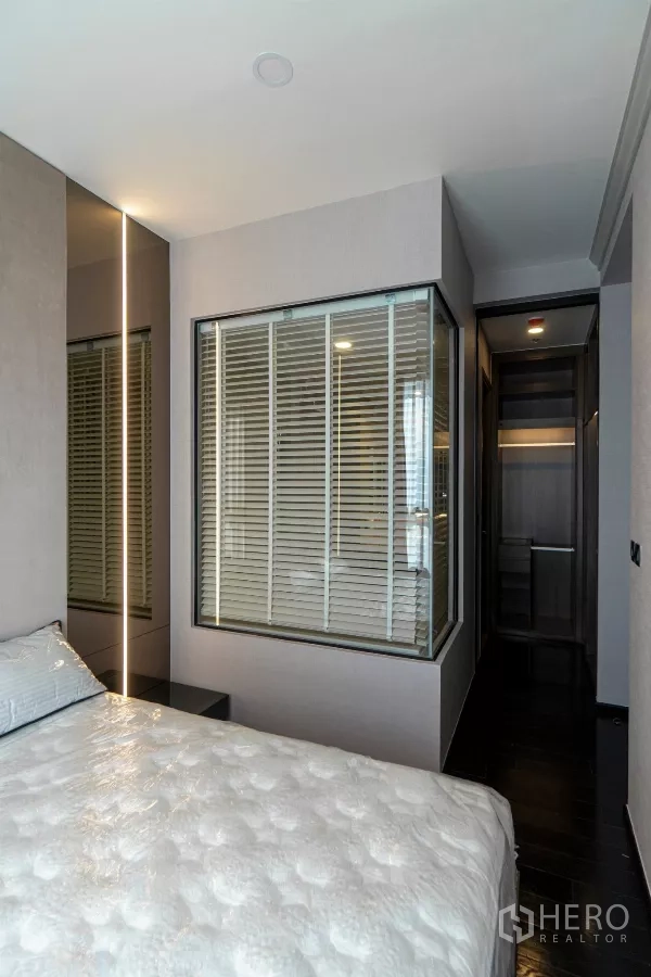 公寓 出租在Watthana, Bangkok - 卧室视角，可见衣帽间与带百叶的浴室窗。