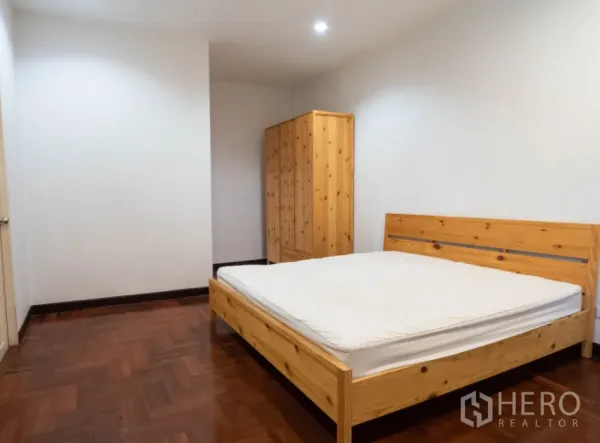 ทาวน์เฮาส์ ให้เช่าในKhlong Toei, Bangkok - ห้องนอนสว่างเฟอร์นิเจอร์ไม้ เตียงและตู้เสื้อผ้า กับพื้นปาเกต์