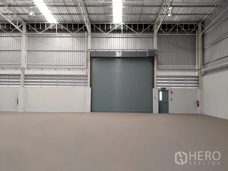 Factory for rent or sale in Samut Prakan - Interior view of loading door with ventilation louvres, emergency exit and fire equipment.