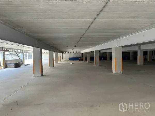 Warehouse for rent in Lat Krabang, Bangkok - Open undercroft area with concrete floor and support columns for covered storage or parking.