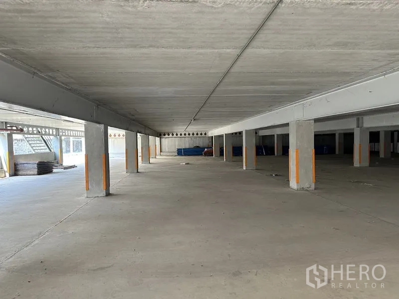 Warehouse for rent in Lat Krabang, Bangkok - Open undercroft area with concrete floor and support columns for covered storage or parking.