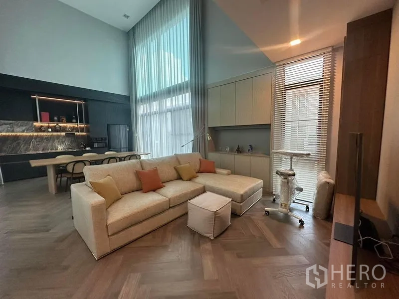Detached House for sale in Saphan Sung, Bangkok - Cozy family sitting area under a soaring ceiling with built-in cabinetry beside the dining zone.
