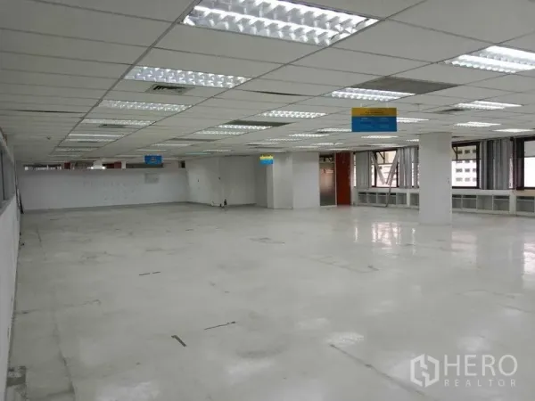 Office Space for rent in Watthana, Bangkok - Expansive open-plan office floor with grid ceiling, fluorescent lights, columns and perimeter windows.