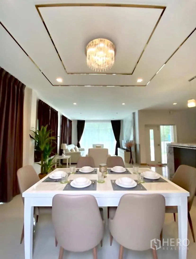 独立式住宅 出租或出售在Prawet, Bangkok - 明亮餐厅，六人餐桌与水晶吊灯。